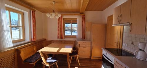 a small kitchen with a wooden table and chairs at Gindlhütte in Tauplitzalm