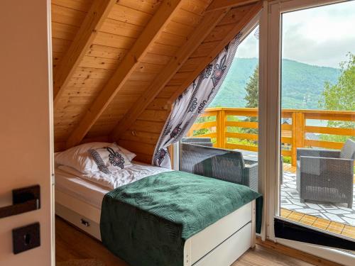 a bedroom with a bed and a balcony with a window at Willa Wilk in Międzybrodzie Bialskie