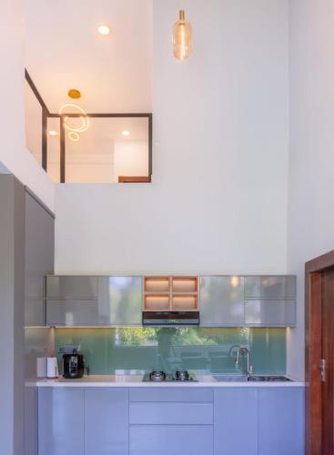 a kitchen with white cabinets and a sink at The cloud ella in Ella