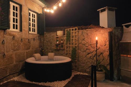 a bath tub in a room with a stone wall at Regouro - an Hidden Gem in Douro Valley in Boassas
