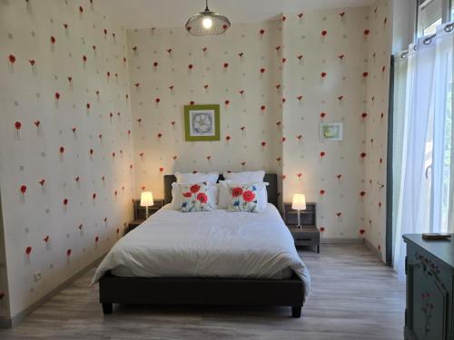a bedroom with a bed with red flowers on the wall at Villa Honorine in Saint-Honoré-les-Bains