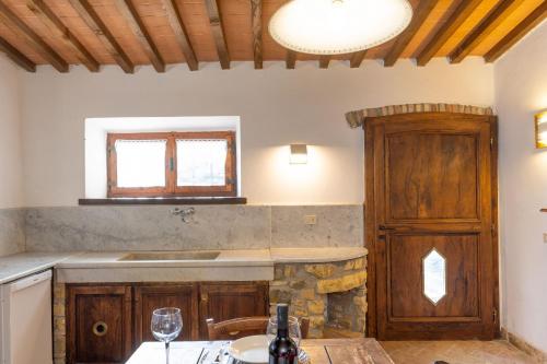 a kitchen with a sink and a wooden cabinet at Le Querciolaie with Geothermal Pool - by PosarelliVillas in Monteverdi Marittimo