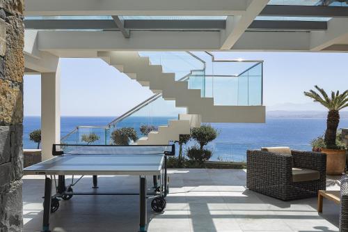 a patio with a table and stairs and the ocean at Candia Lux in Heraklio