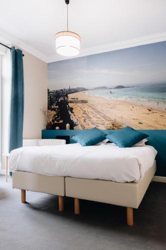 a bedroom with a bed with a painting of a beach at La Villa du Sillon by les Ambassadeurs - Saint Malo Plage in Saint Malo