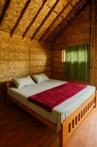 a bedroom with a large bed in a wooden room at Ecospace Kabini in Kabini River