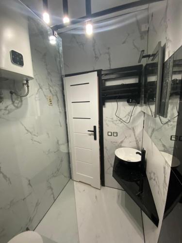 a bathroom with a white toilet and a door at Appartamento Antares Piazza Fontana in Lignano Sabbiadoro