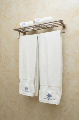 a group of white towels hanging on a towel rack at Hotel Britania in Tirana