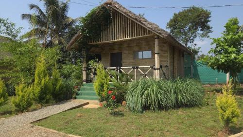 a small house with a porch and some plants at Ecospace Kabini in Kabini River