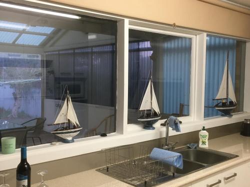a kitchen window with three sail boats in it at Goolwa Retreat in Goolwa North