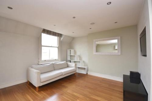 a living room with a white couch and a window at Flat 4, 15 Ethelbert Square CT8 8SR in Westgate-on-Sea