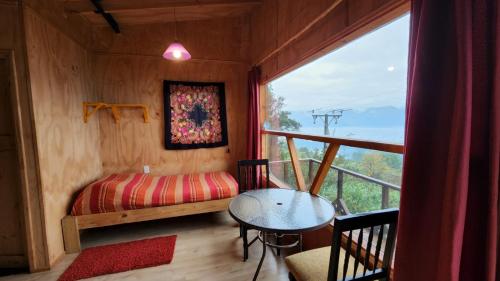 a room with a bed and a table and a window at HOSTAL TORRE DEL ESPAÑOL in Valdivia