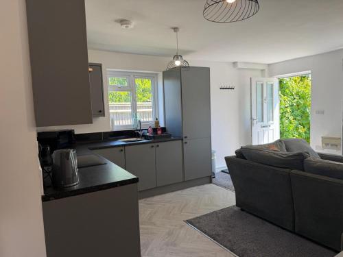 a kitchen and a living room with a couch at Gatwick 2 Bed Apartments Free Parking in Horley