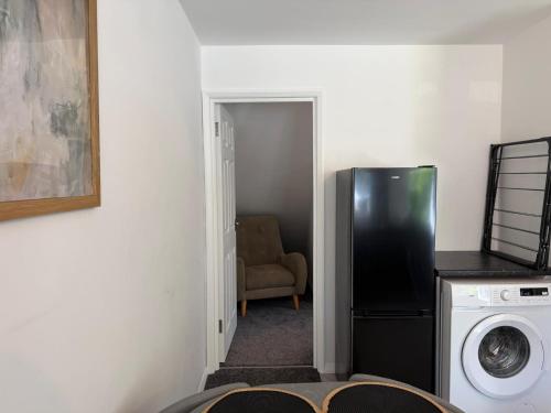 a kitchen with a black refrigerator in a room at Gatwick 2 Bed Apartments Free Parking in Horley