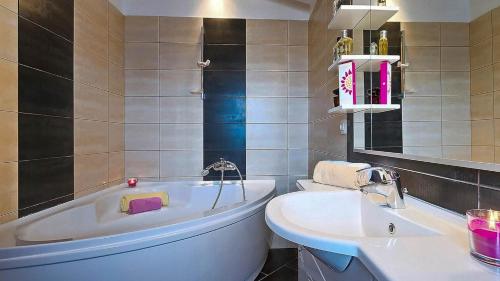 a bathroom with a tub and a sink at Sonnengarten floor 2 in Marčana