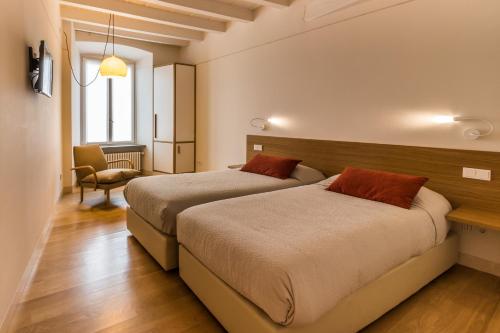 1 dormitorio con 2 camas y 1 silla en Belle Arti, en Bérgamo