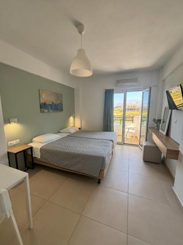 a large bedroom with a bed and a balcony at Kostas Apartments in Stalís
