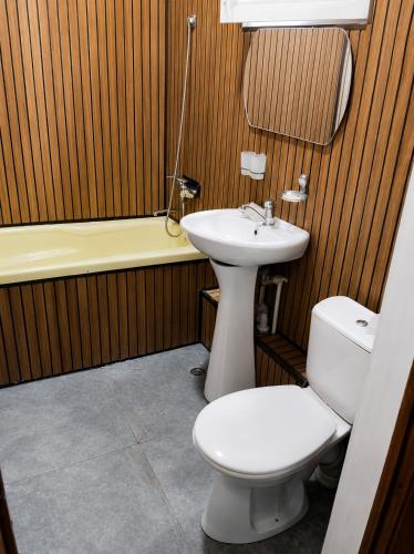 a bathroom with a toilet and a sink and a tub at Ayvan Eco Hostel in Tashkent