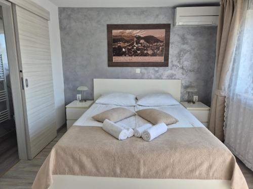 a bedroom with a bed with two pillows on it at Apartments & Rooms Aleksandra in Bled