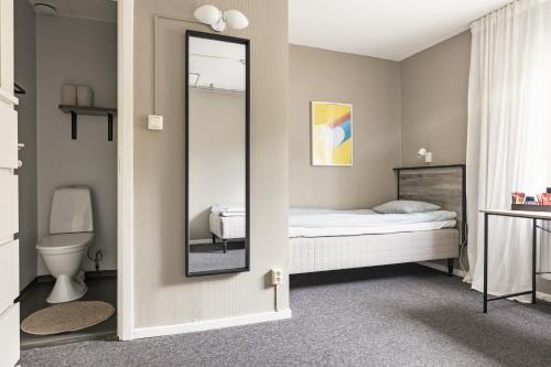a bedroom with a mirror and a bed at Hakefjorden by Workershotel in Källsby