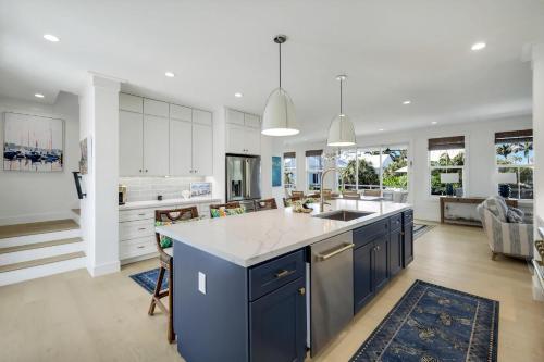 a kitchen with white cabinets and a blue island at Cabana Blu in Captiva