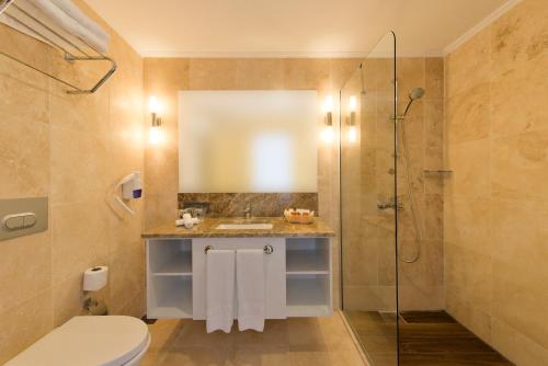 a bathroom with a shower and a toilet and a sink at Bellazure Hotel in Akyarlar
