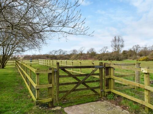 a wooden fence in the middle of a field at Quail Cottage - Uk50659 in Little Singleton