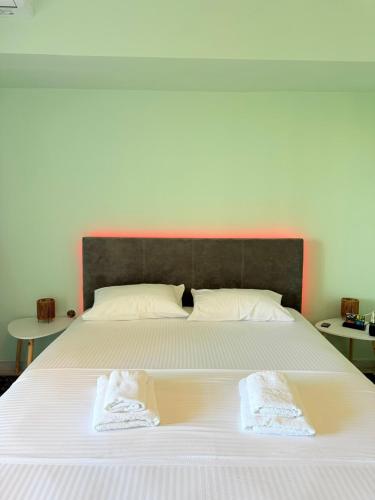 a large white bed with two towels on it at Hermes View in Kavála
