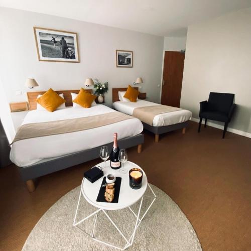 a hotel room with two beds and a table with a tray of food at Hotel les voyageurs in Saint-Renan