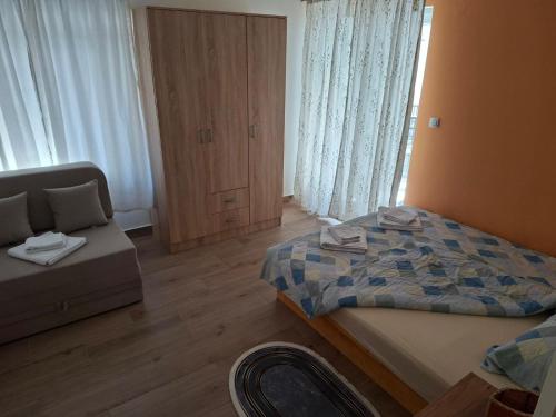 a bedroom with a bed and a couch in it at Stan na dan Emili 2 in Valjevo