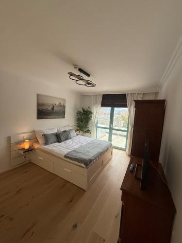 a bedroom with a bed and a large window at Penthouse Panorama Seeblick in Gmunden