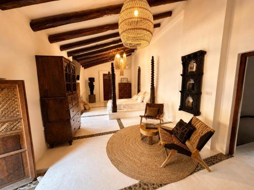 a living room with a couch and chairs and a chandelier at Finca Dariana Padel & Pool in Alora