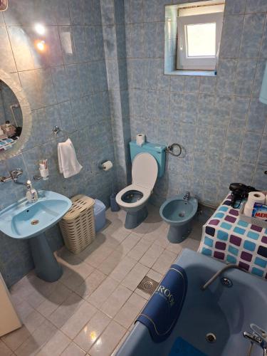 a bathroom with two toilets and a sink and a tub at Stan na dan Emili 2 in Valjevo
