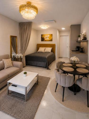 a living room with a bed and a table at Maluno vilos apartamentas su terasa in Palanga