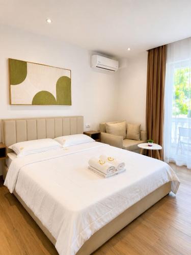 a bedroom with a large white bed and a couch at Vila Beqja in Durrës