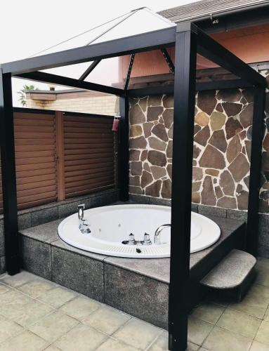 a large tub in a room with a stone wall at バリアンリゾート山口BarianResort Yamaguchi in Sanyoonoda