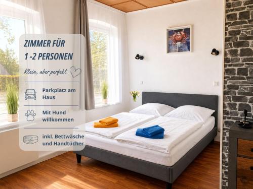 a bed in a room with a sign on the wall at Zimmer Haus Krabbe für Kurzaufenthalt und Geschäftsreise, zwischen Bremerhaven und Cuxhaven in Wremen