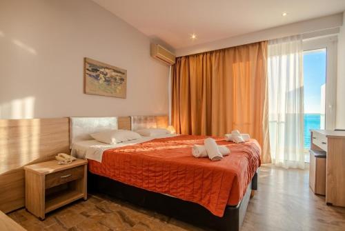 a hotel room with a bed and a large window at Alyssium in Benitses