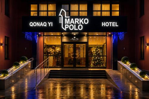 a store front of a marco polo hotel at night at Marko Polo Hotel in Aksay