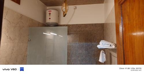 a small bathroom with a shower with aperature at Tranquil Nature Resort in Rāipur