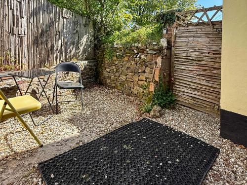 a patio with a table and a chair and a fence at Serendipity in Molland