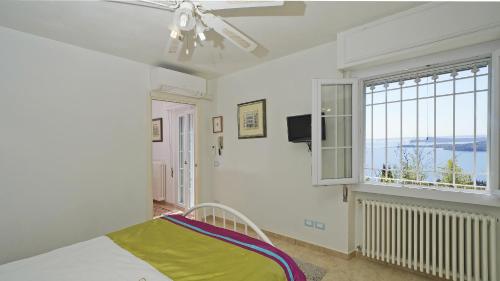 a bedroom with a bed and a window at Villa Samanta in Gardone Riviera