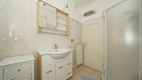 a white bathroom with a sink and a shower at Villa Samanta in Gardone Riviera