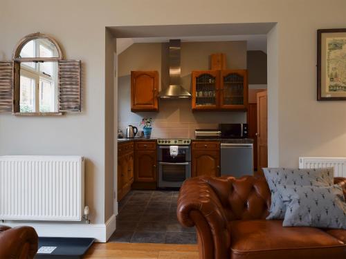a living room with a couch and a kitchen at The Coach House in Great Malvern