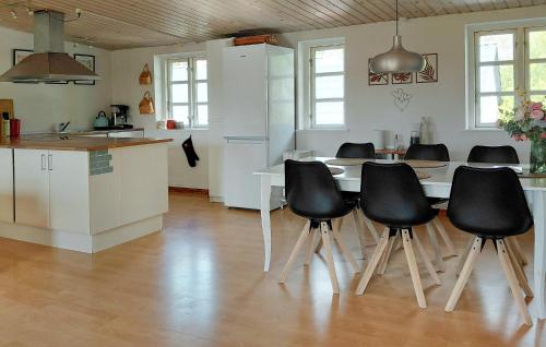 a kitchen with a table and some black chairs at 2 Bedroom Lovely Apartment In Gørlev in Gørlev