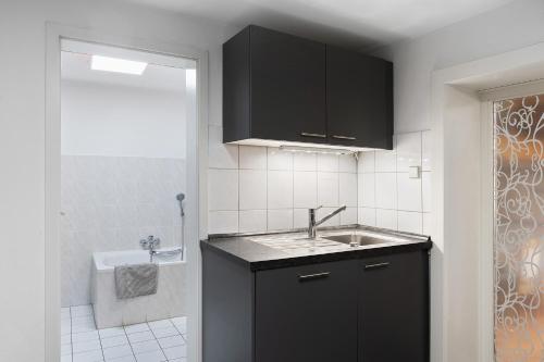 a small kitchen with a sink and a tub at Ferienwohnung Stadthaus in Mellrichstadt