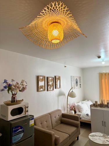 a living room with a couch and a chandelier at La Casa Del Comienzo- Plumera Mactan Near Airport in Lapu Lapu City