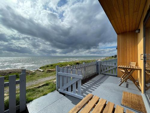 a porch of a house with a view of the ocean at Sunrise Summerhouse in Hilton of Cadboll