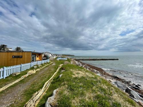 a house on the shore of a body of water at Sunrise Summerhouse in Hilton of Cadboll