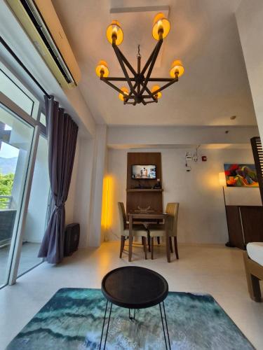 a dining room with a table and a chandelier at Tropical Escape at Pico De Loro in Nasugbu