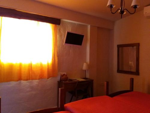 a bedroom with a bed and a window and a desk at Virgen De Los Remedios in Arroyomolinos de León